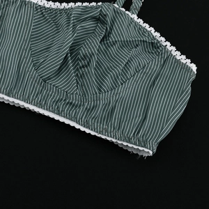 Close-up of green striped camisole with white lace trim and silky fabric details