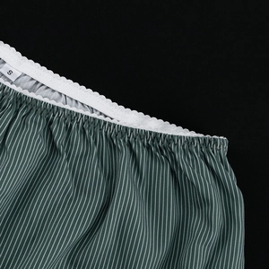 Detail of green and white striped fabric with wavy elastic waistband and size S tag