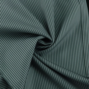 Macro detail of vertical green and white stripes on fine textile fabric with silky texture