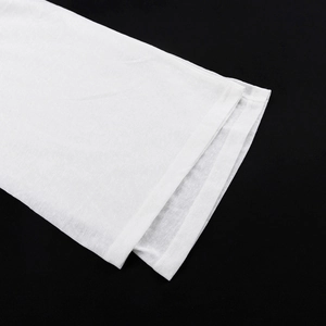Dettaglio della trama in maglia bianca e delle cuciture rifinite sul bordo della manica