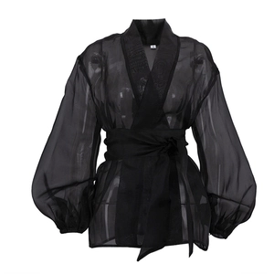 Detail of black sheer organza blouse with V-neck wrap tie waist and puffed lantern sleeves