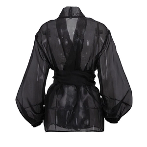 Detail of sheer black V-neck blouse featuring elegant puff sleeves and a waist tie