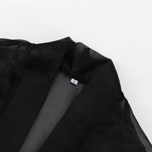 Close-up of neckline stitching and size S label on black sheer mesh long sleeve top