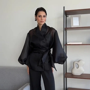 Elegant black sheer puff sleeve V-neck wrap blouse for women in minimalist modern setting