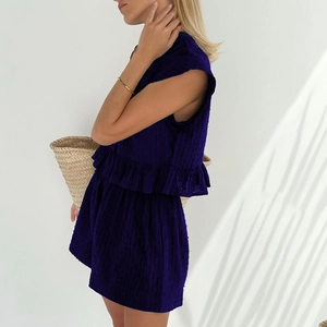 Detail of dark blue two-piece set featuring ruffle sleeveless top and textured shorts