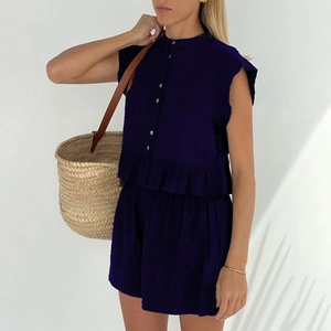 Detail of navy two-piece set featuring textured jacquard fabric and ruffle hem design