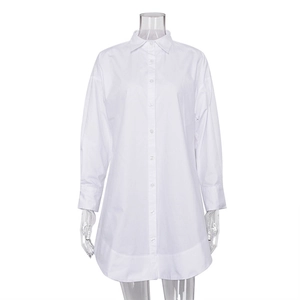 Détail d'une robe chemise blanche à manches longues ample avec col à revers et ourlet arrondi
