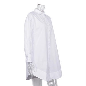 Détail d'une chemise blanche boutonnée avec silhouette ample et ourlet arrondi