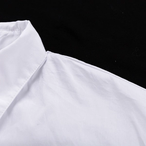 Gros plan détaillé du col rabattu et des coutures d'épaule d'une chemise en coton blanc