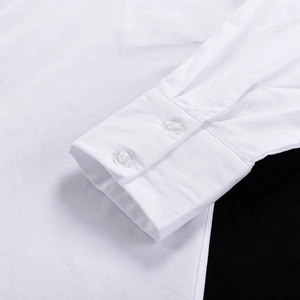 Détail des poignets à double boutonnage d'une chemise blanche à manches longues chic