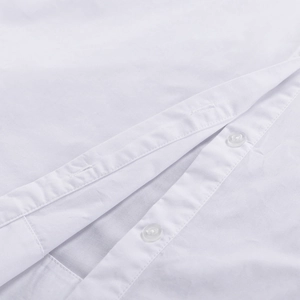 Détail de la patte de boutonnage de chemise blanche avec boutons en résine et coutures propres