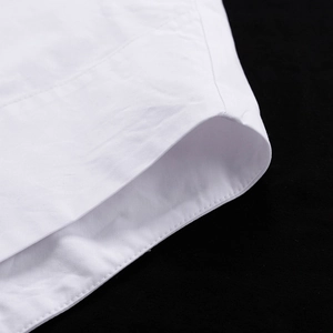 Détail de la manchette d'une chemise en coton blanc avec couture double aiguille