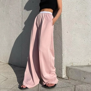 Détail du pantalon large rose à taille haute avec ceinture élastique blanche