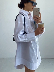 Chemise blanche oversize à manches longues avec revers et poignets larges superposés