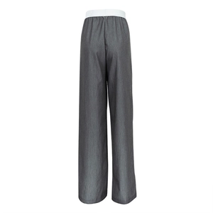 Détail de pantalon large gris foncé avec une taille élastique blanche contrastée au dos