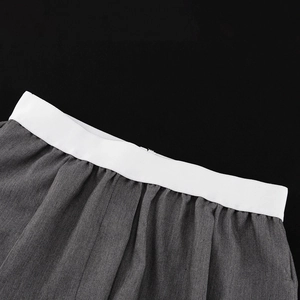 Détail de la taille élastique blanche sur le pantalon plissé gris à jambes larges