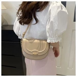 Seitenansicht der eleganten aprikosenfarbenen Satteltasche mit goldenem Ringverschluss