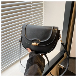 Details der schwarzen Satteltasche mit glattem Leder und goldenem Zylinderverschluss
