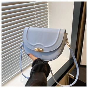 Detail der hellblauen PU-Satteltasche mit goldenem zylindrischem Drehverschluss für Damen