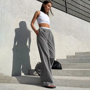 Pantalon large pour femme à taille haute et crop top blanc dans un décor extérieur chic