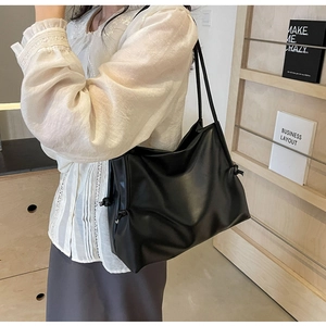 Dettaglio della borsa tote nera in ecopelle con eleganti nodi a coulisse e trama morbida