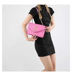 Nahaufnahme der pinkfarbenen Stepptasche mit goldenem S-Verschluss und Kettenteil-Quaste