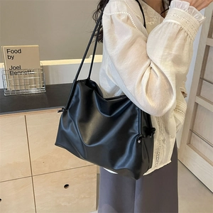 Bolso tote minimalista de cuero negro con detalles de cordón lateral y correas dobles