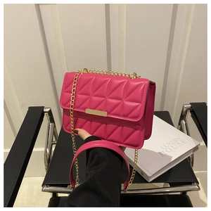 Close-up of hot pink quilted crossbody bag with gold chain strap and metal clasp