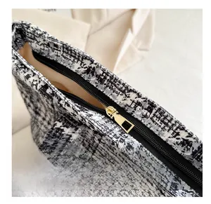 Close-up of smooth metal zipper and gray tweed fabric on large capacity tote bag