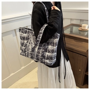 Classic black and white tweed checkerboard tote bag shown on model for elegant daily use