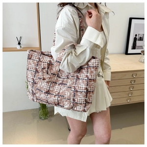 Detailed view of checkered tote bag in brown and white tweed with wide shoulder straps