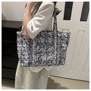 Close-up of black and white houndstooth pattern texture on a stylish tote bag