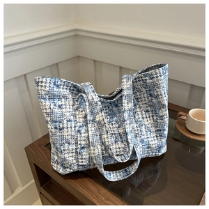 Close-up of blue and white checkered woven fabric texture on a fashion tote bag