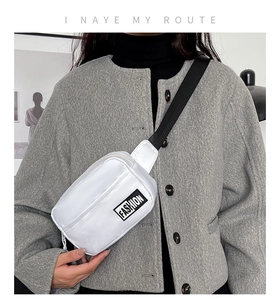 Detail of white nylon crossbody bag featuring a black 'FASHION' label and wide strap