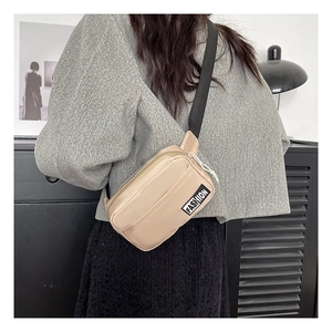 Detail of khaki nylon phone bag featuring adjustable strap and fashion label on front
