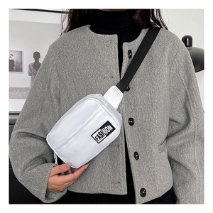 Detail of white nylon chest bag with black FASHION label and adjustable strap