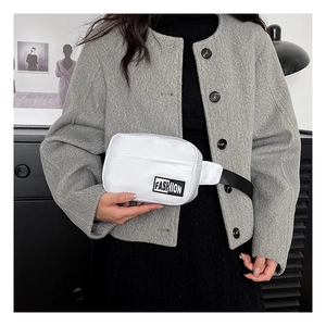 Detail of white quilted nylon crossbody bag with adjustable strap worn by a model