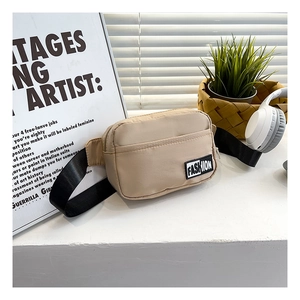 Detail of beige nylon crossbody bag with fashion label and adjustable black strap