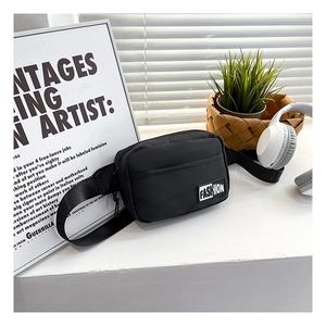 Close-up of black nylon crossbody bag featuring a front zipper pocket and fashion label