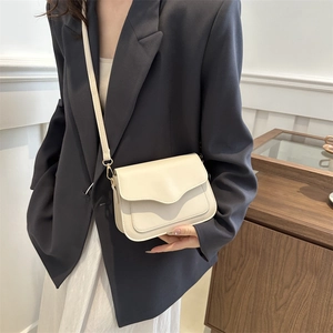 Sac bandoulière chic en cuir blanc crème pour femmes avec rabat ondulé élégant