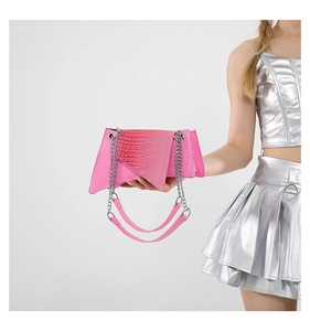 Détail du sac géométrique rose vif avec texture crocodile et chaîne en argent