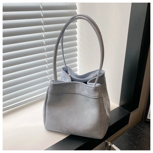 Minimalist light blue faux suede tote bag with slim dual handles in soft natural light