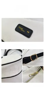 Détails du sac blanc texturé avec ferrures dorées et étiquette de marque en cuir noir
