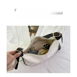 Vue intérieure détaillée d'un sac demi-lune blanc montrant une grande capacité de rangement