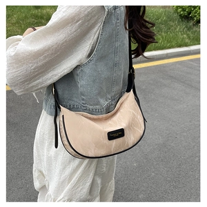 Détail d'un sac demi-lune couleur thé au lait avec texture marbre et sangle large
