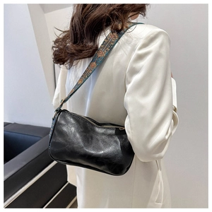 Détail du sac à main noir en similicuir avec bandoulière aux motifs ethniques