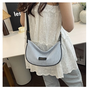 Gros plan du sac hobo croissant bleu clair avec texture plissée élégante et design