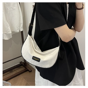 Détail du sac demi-lune blanc en tissu jacquard texturé et bordure en cuir noir