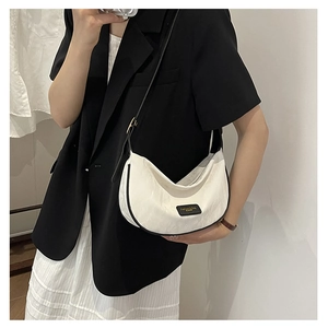 Sac demi-lune blanc minimaliste avec passepoil noir et étiquette de logo contrastée