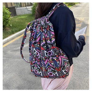 Outdoor view of a colorful bohemian drawstring canvas backpack with geometric patterns